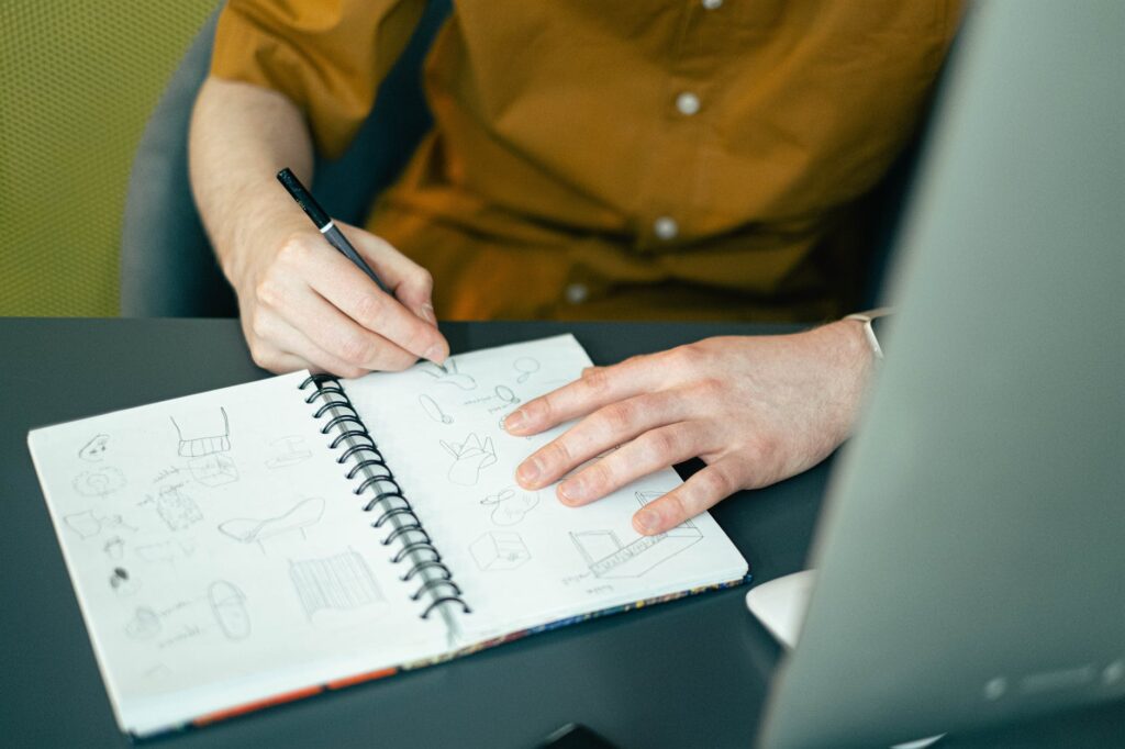 person sketching on a notebook